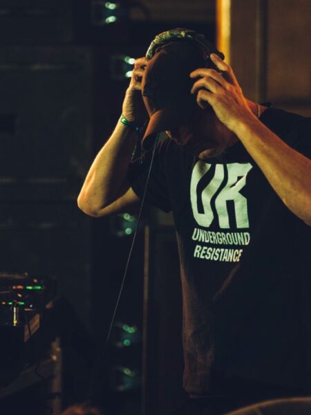 Greg about to put headphones on and lock in. Wearing a black tshirt with Underground Resistance text.